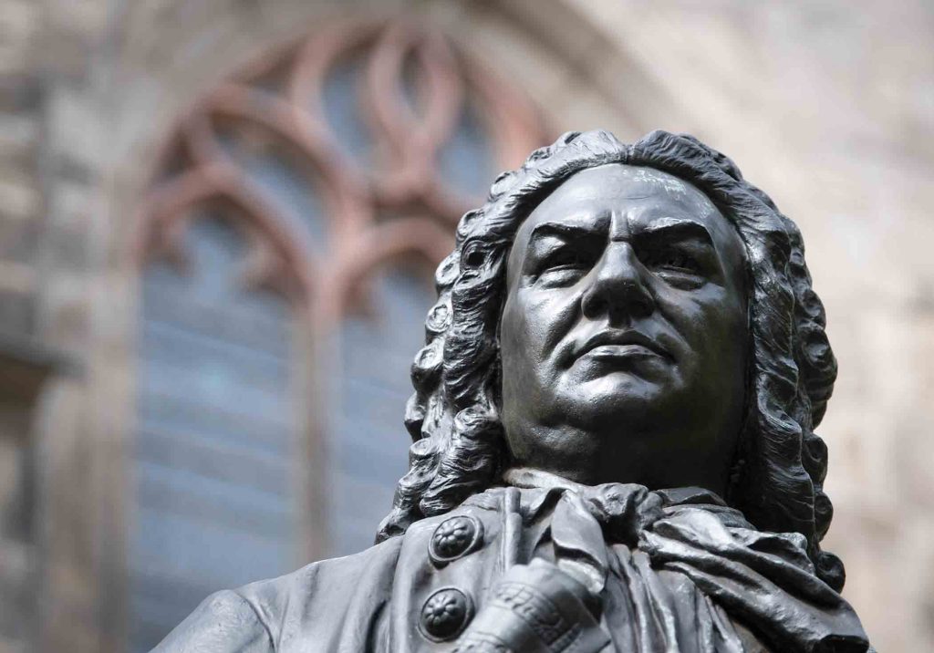 Low-angle close-up view of the bronze statue of Johann Sebastian Bach outside St. Thomas Church.