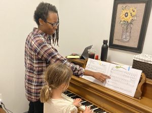 Piano teacher supporting a piano students musical journey through structured education.