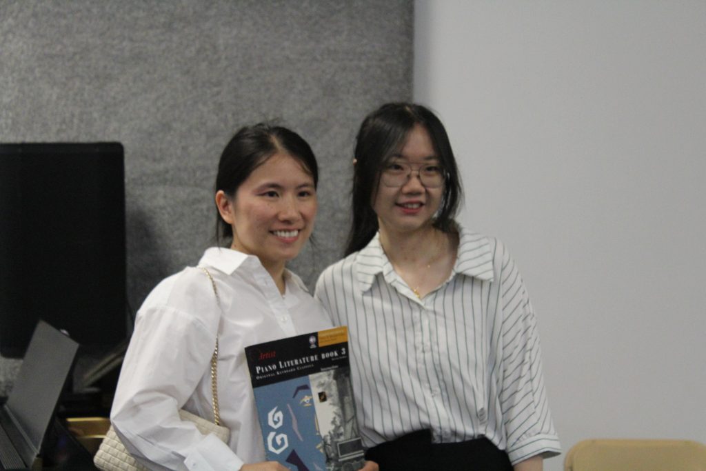 Piano Teacher Pufan posing with student after recital