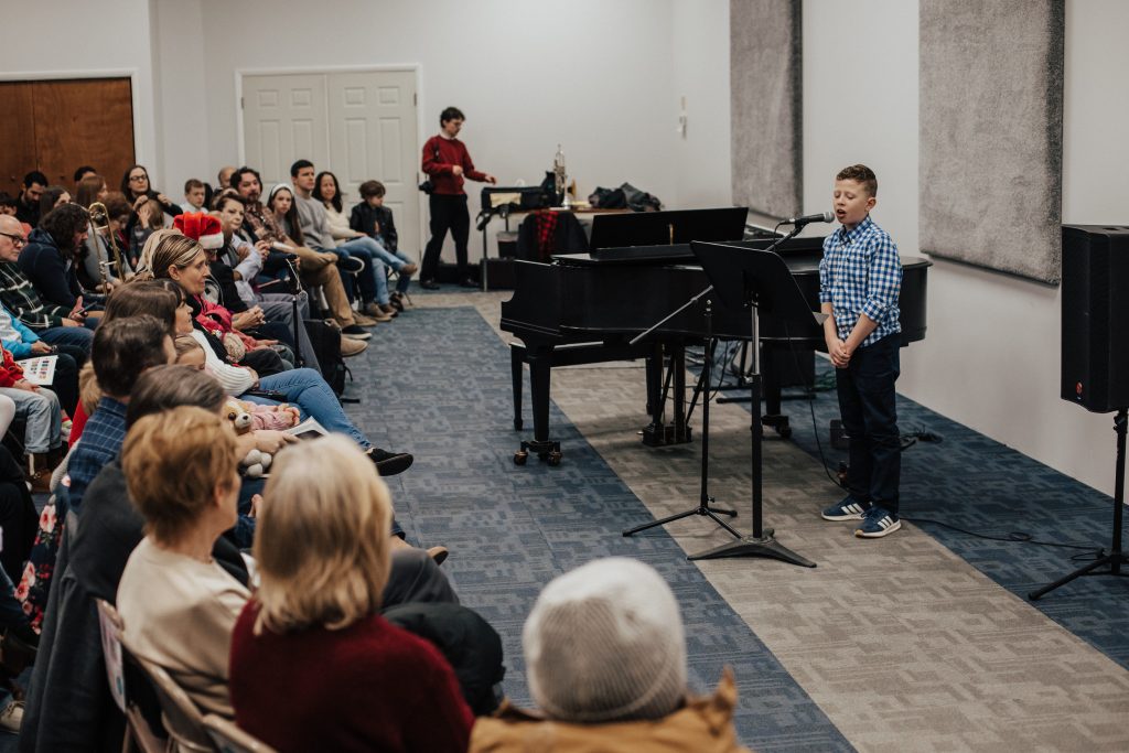 Young musician performing for family members during the Life at Chambers Festival.