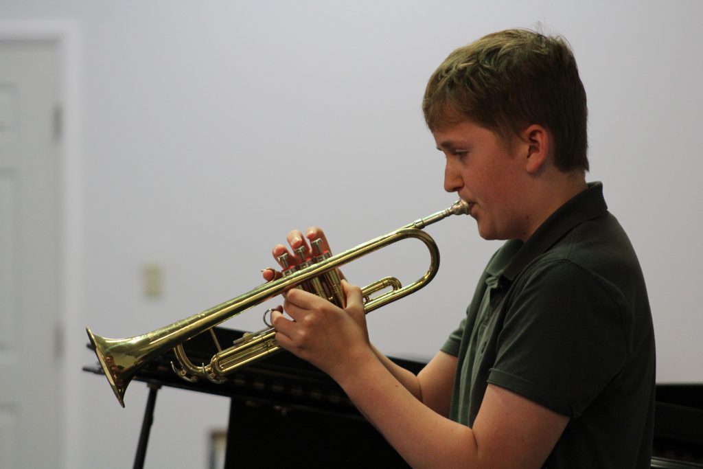 Adult musicians supporting one another during a student Music Showcase.