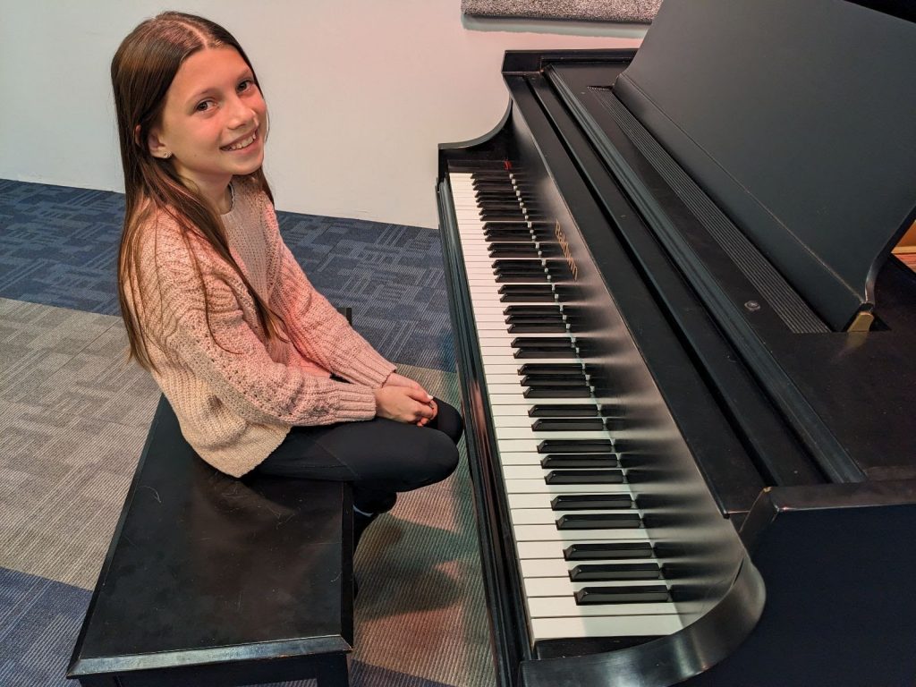 Elementary student taking piano lessons in Columbus Ohio during back-to-school season.