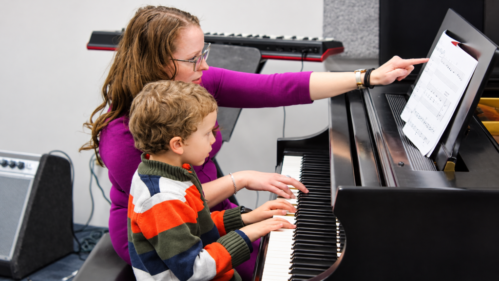 Julie guiding a young student during a piano lesson at Chambers Music Studio.
