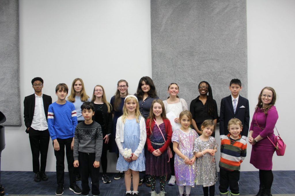 Families and children in a bright, welcoming music studio lobby at Chambers Music Studio in Columbus, Ohio, offering piano lessons and music classes for kids and adults in a community-centered environment.