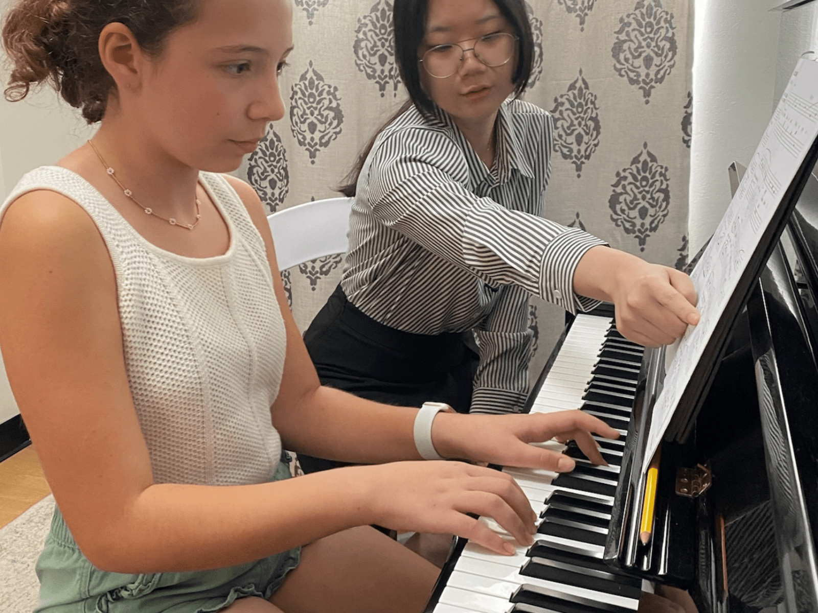 A music teacher teaching a piano student how to play scales using the correct fingering in a steady pace with supportive encouragement.